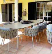 Vallee Rattan Outdoor Dining Table Set, Table With Six Dining Chairs in a lifestyle setting with comfortable sofa bed