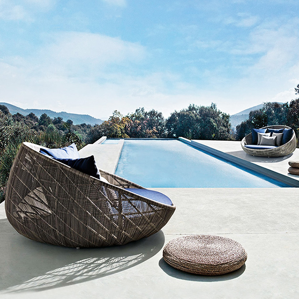 Elysia Rattan Round Outdoor Daybed in a lifestyle setting with sofa bed and chair