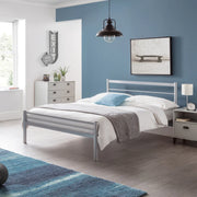 Modern bedroom with a metal bed, blue walls, and decorative elements. Iconic abode