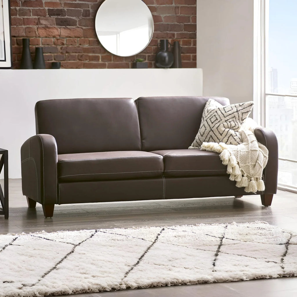Brown leather sofa with a patterned throw blanket in a living room setting Iconic abode.